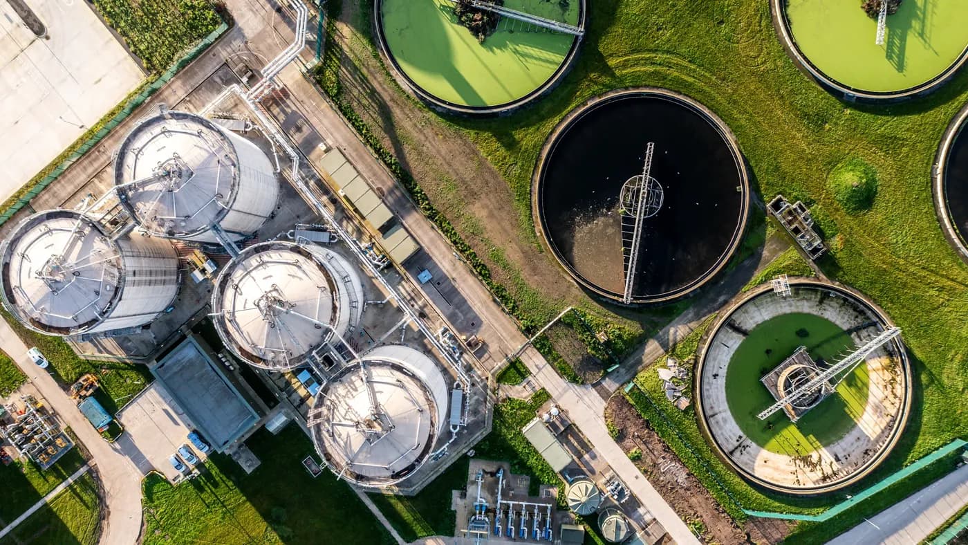An aerial view directly above a waste water treatment works with circular storage tanks filtering wastewater for drinking water