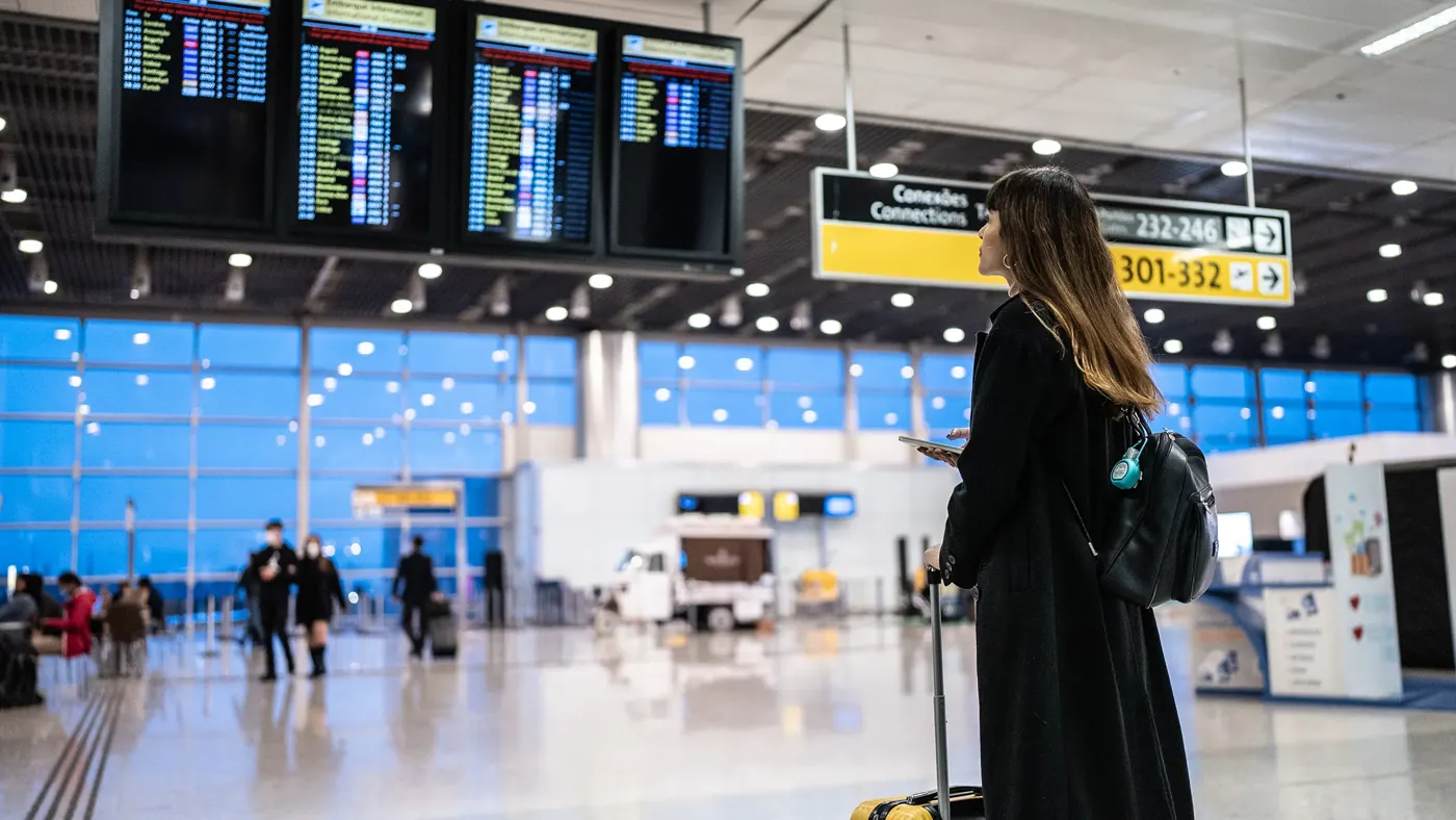 Portrait of a young woman using the mobile phone in the airport