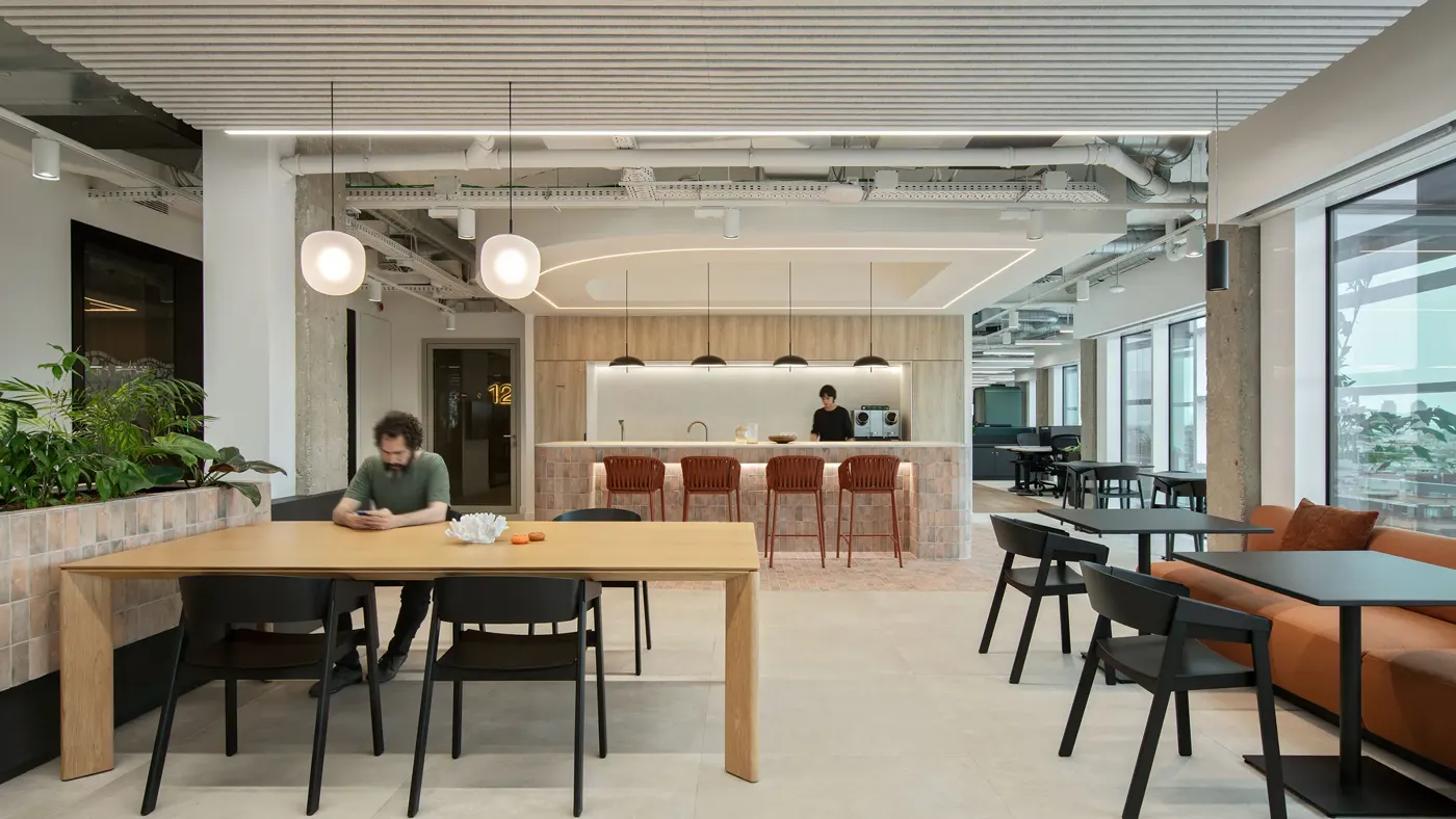 Modern office breakout area with tables, seating and a cafe style counter
